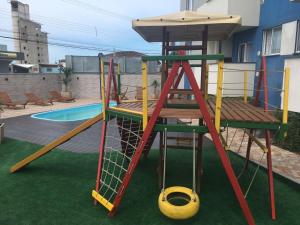 un parque infantil con tobogán y columpio en Apartamento em Penha SC, en Penha