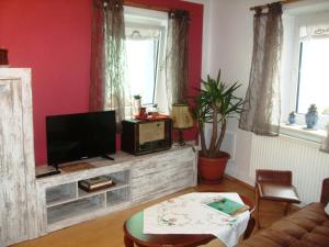 a living room with a tv on a wooden entertainment center at Ferienwohnung Örtl 7 in Obernzell +41 photos