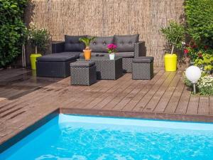 a patio with a couch and chairs and a pool at Les abysses in Richwiller