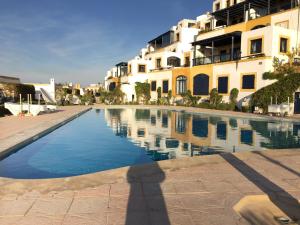 a swimming pool in front of a building at Villa Jardins de la Lagune in Oualidia