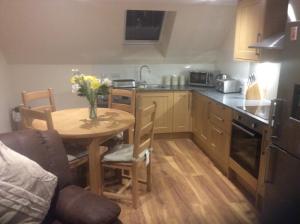 eine Küche mit einem Tisch und einer Blumenvase darauf in der Unterkunft Druid Apartment in Inverness