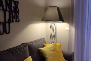 una lampada seduta accanto a un divano con cuscini gialli di Imbriani Guest House a Bari