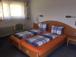 a bedroom with two beds with blue and white pillows at Landgasthaus Waldschänke in Emmendingen