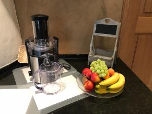 a bowl of fruit on a counter next to a blender at Hotel BZ Sunnahof in Oberschan