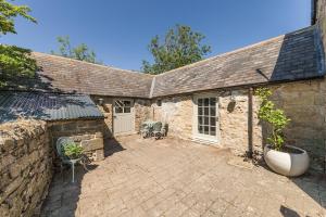 an old stone house with a large patio at Shellbraes Studio in Ryal