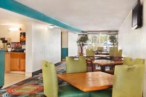 a restaurant with tables and chairs and a kitchen at Express Inn and Suites in Little Rock