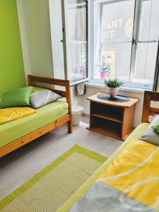 Zimmer mit 2 Betten, einem Tisch und einem Fenster in der Unterkunft Gemütliche 4 Zimmer Whg in der Residenz Elisabeth in Bad Ischl