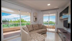 ein Wohnzimmer mit einem Sofa und einem TV in der Unterkunft Apartaments Cambrils Suite Costa Daurada in Cambrils