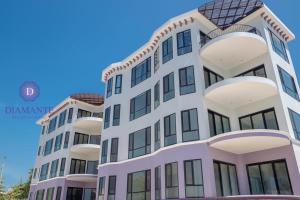 un grand bâtiment avec un ciel bleu en arrière-plan dans l'établissement Diamante Beachfront Suites, à San Pedro