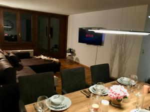 a living room with a table and chairs and a television at Breathtaking Waterfall Apartment in Lauterbrunnen