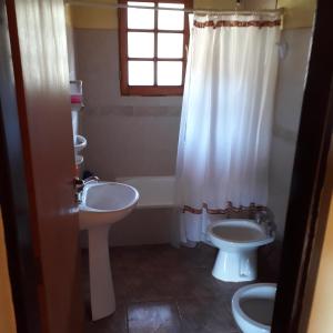 a bathroom with two sinks and a toilet and a window at Cabañas Bahia Radal in Villa Pehuenia