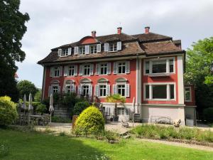 a large red house with a lawn in front of it at Villa Jakobsbrunnen in Winterthur