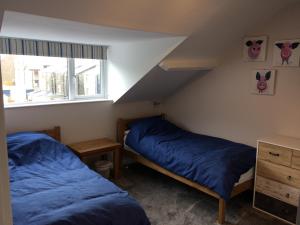 1 dormitorio con 2 camas y ventana en Swyn y Mor beach close Pet friendly hot tub, en Barmouth