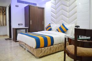 1 dormitorio con cama, mesa y escritorio en Hotel Sun International, en Nueva Delhi
