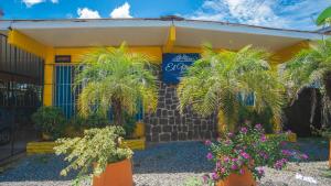 ein Gebäude mit Palmen und Blumen davor in der Unterkunft Residencial El Viajero in David