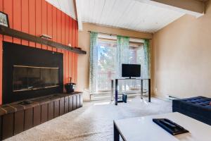 a living room with a fireplace and a tv at One-Bedroom Sundowner Condo T4 in Breckenridge