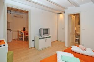 een woonkamer met een bank en een tv bij Studio Čikato in Dubrovnik