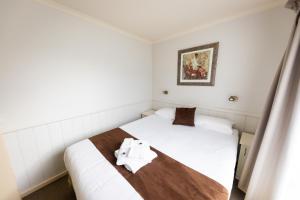 two beds in a room with white walls at BIG4 Breeze Holiday Parks - Eildon in Eildon