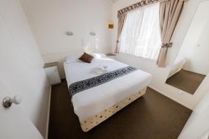 a small room with a bed and a mirror at BIG4 Breeze Holiday Parks - Eildon in Eildon