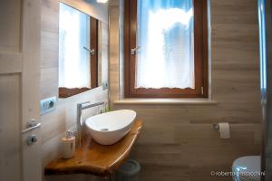 a bathroom with a bowl sink on a wooden counter at La casa di Primo in Montecosaro