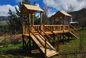 a wooden playground with two gazebos in a field at Cabañas Kuyen in Coihaique +31 photos