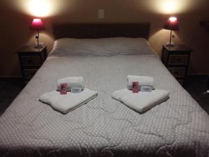 Un dormitorio con una cama con toallas y tazas. en Hospedaje Doña Velia en Purmamarca