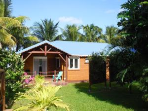 a cottage on the beach with palm trees at Gîtes LAMATELIANE in Capesterre-Belle-Eau