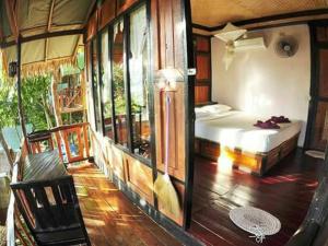 Zimmer mit einem Schlafzimmer mit einem Bett und Fenstern in der Unterkunft Phi Phi Green Hill Resort in Ko Phi Phi