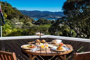 a table with food on a balcony with a view at Grand Mercure Puka Park Resort in Pauanui