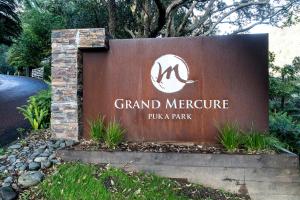 a sign for the grand mercure pula park at Grand Mercure Puka Park Resort in Pauanui