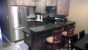 una cocina con armarios de madera y una isla de cocina con taburetes en 107 Pike on Oceanside, en South Padre Island