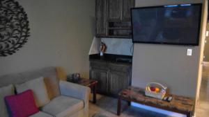sala de estar con sofá y TV de pantalla plana en 107 Pike on Oceanside en South Padre Island