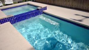 uma piscina com azulejos azuis em cima em 107 Pike on Oceanside em South Padre Island