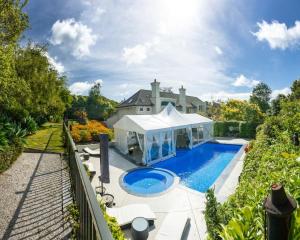 een uitzicht op een huis met een zwembad bij Greenmantle Estate Hotel in Paraparaumu