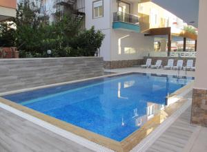 a large blue swimming pool in front of a house at Cozy apartment Centr Alanya in Alanya