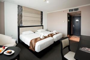 una camera d'albergo con un letto con asciugamani sopra di Grand Arkenso Park View a Semarang