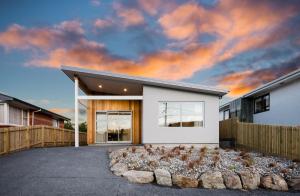 a house with a bunch of birds sitting in front of it at The Beach House in Dunedin