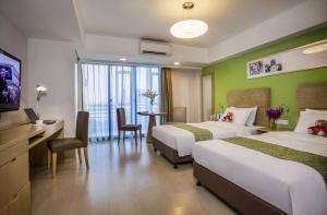 a hotel room with two beds and a desk and a television at Citadines Zhuankou Wuhan in Wuhan