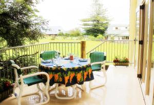 een tafel en vier stoelen op een balkon met een tafel en stoelen bij The Carriage House-Bay of Islands in Kerikeri