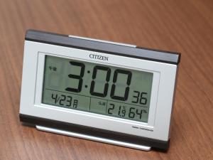an alarm clock sitting on top of a wooden table at Hotel Wing International Select Ueno Okachimachi in Tokyo