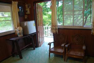 a living room with a chair and a refrigerator at Prue Sa Raj in Phetchabun