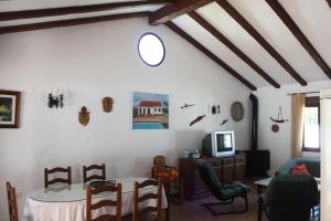 sala de estar con mesa y TV en Villa Mayorazgo-Solo Familias, en Conil de la Frontera