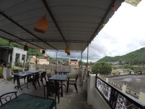 eine Terrasse mit Tischen und Stühlen auf dem Balkon in der Unterkunft Shivam Tourist Guest House in Bundi
