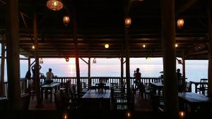 a restaurant with tables and chairs and a view of the ocean at Free Beach Resort in Phú Quốc