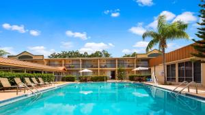una piscina di fronte a un hotel con sedie e un edificio di Best Western Orlando West a Orlando