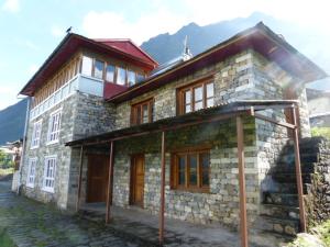 een groot stenen gebouw met ramen en een dak bij Lukla Airport Resort Lukla in Lukla