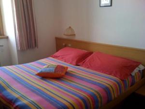 
a bed with a blue and white comforter and pillows at Hotel Genziana in Passo Stelvio
