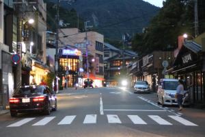 una strada di città di notte con auto che guidano lungo la strada di Arima Onsen Koki a Kobe