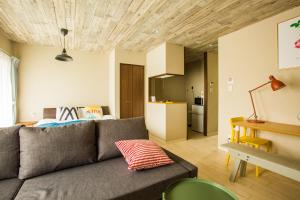a living room with a couch and a kitchen at Sky Living Namba in Osaka
