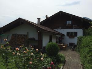une maison avec une terrasse et des fleurs devant elle dans l'établissement Ferienwohnung Heilingbrunner, à Bad Wiessee